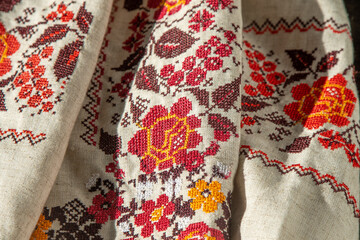 Ukrainian clothes embroidered shirt. Red orange and black threads background. Vyshyvanka is a symbol of Ukraine. Embroidery cross stitching. National Ukrainian stitch. Traditional clothing symbol.