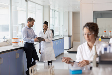 Scientists discussing data using a digital tablet in a laboratory