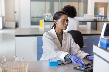 Female scientist inputting data on a computer in a laboratory