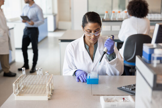 Female scientist pipetting in laboratory  - Powered by Adobe