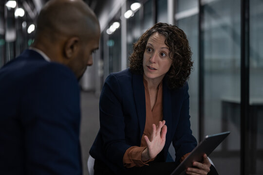 Businesswoman working late in an office with a colleague on a deadline