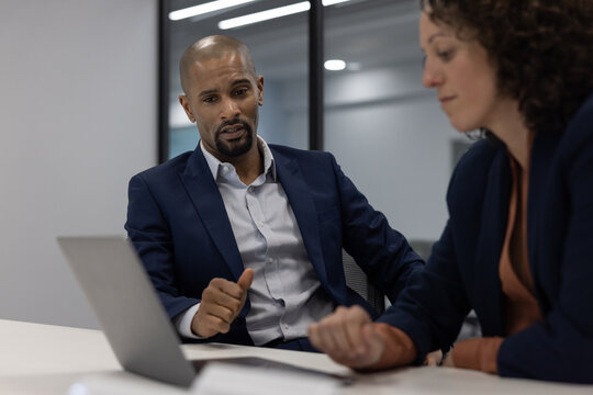 Businessman working late in an office with a colleague on a deadline