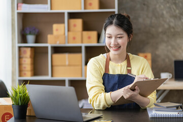 Small business start-up, SME owner, two Asian women checking online orders Sell ​​goods, work with boxes. freelance work at home office online sme business