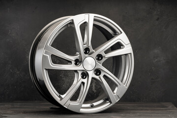 silver alloy wheels auto parts in the form of a star on a black textured background.