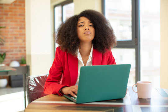 pretty afro black woman feeling sad and whiney with an unhappy look and crying. businesswoman and laptop concept