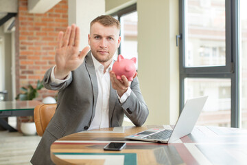 looking serious showing open palm making stop gesture. business piggy bank