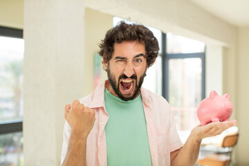 crazy bearded man looking angry, annoyed and frustrated. piggy bank concept