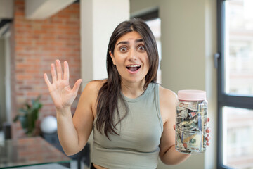 young woman feeling happy and astonished at something unbelievable. dollar banknotes
