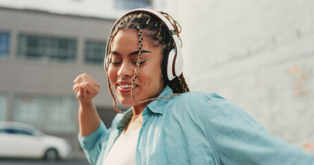 Woman, dancing and listening to music in the city with headphones for audio streaming in the outdoors. Happy female dancer enjoying 5G connection with headset to listen for sound track in urban town