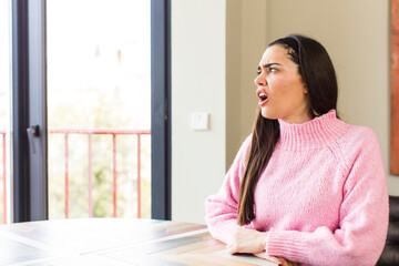 pretty caucasian woman feeling shocked and surprised, looking to copy space on the side with amazed, open-mouthed look