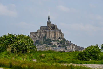 Obraz premium Mont Saint-Michel, Abtei, Felseninsel, Kloster, Wanderweg, Insel, Abteikirche, Befestigungsanlage, Granitfelsen, Gezeiten, Felder, Landwirtschaft, Bretagne, Sommer, Frankreich