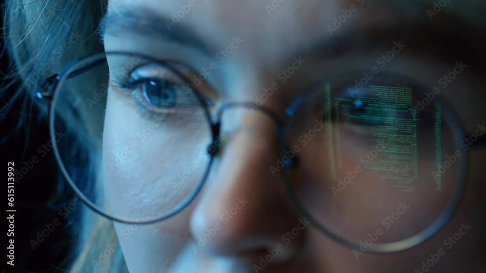 Wall mural extreme close up of woman sitting at desk coding in computer program wearing glasses with reflection