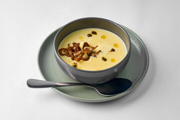 Classic mushroom cream soup with cream in a bowl on a gray background