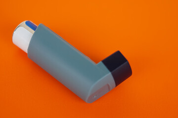 Asthma inhalers on orange background. Concept, Pharmaceutical products for treatment symptoms of asthma or COPD. Use under prescription. Health care device at home.       