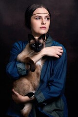 Portrait of pretty young girl in elegant retro clothing over dark vintage background posing with...