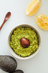 Guacamole with bone white bowl, white background. Healthy food concept.