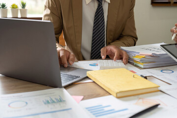 Accountant or bookkeeper using calculator for calculate finance report in office