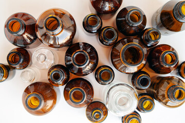 Group of glass medical vials of different sizes. Many small brown and clear glass bottles without labels, top view