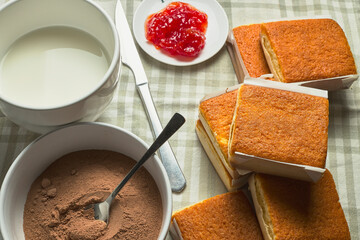Cupcakes. Breakfast table with cocoa, milk, jam and various biscuits, called sobaos and typical of the Cantabria region (Spain)