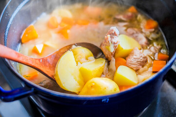 じゃがいもやニンジンを煮込む