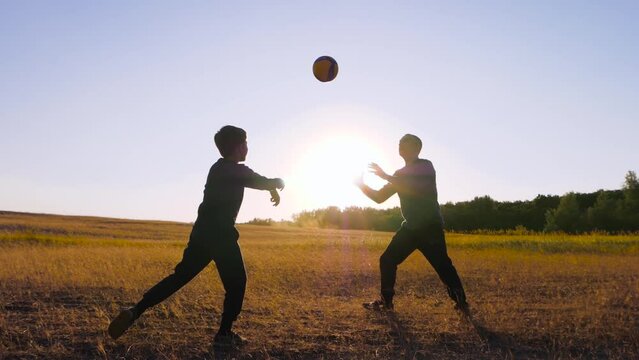 family playing ball. father and son play volleyball at sunset. Kid dream