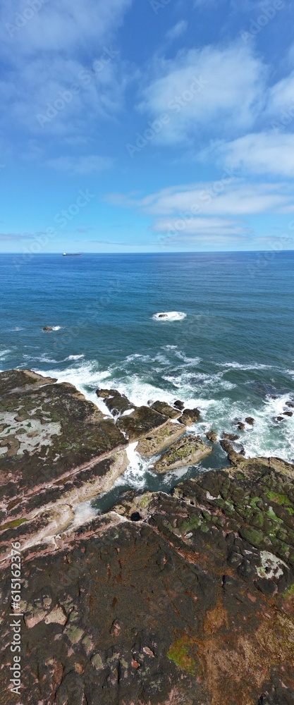 Poster Aerial view of waves crashing onto rocks in Dunbar on the east  coast of Scotland. 