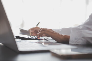 Close up Business woman using calculator and laptop for do math finance on wooden desk, tax, accounting, statistics and analytical research concept - obrazy, fototapety, plakaty