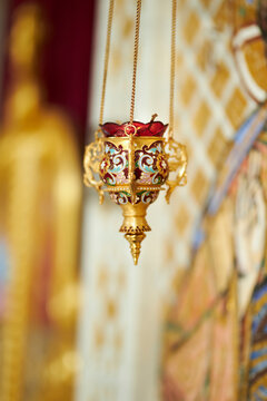 Golden Icon lamp. Golden lampad in front of the icons in the Orthodox Church. Lampad in the church, a burning candle. Orthodox icons in the church. religious concept. Gilded church altarpieces.
