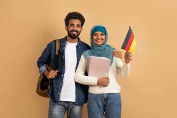 International Education. Arabic Student Couple With Backpacks Holding German Flag