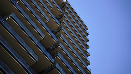 contemporary building facade with balconies against blue sky © Esteve