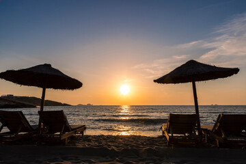 Sun loungers and parasol in sunset on Paros island, Greece