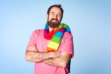 Handsome man with pride movement LGBT Rainbow scarf on shoulder against isolated background.