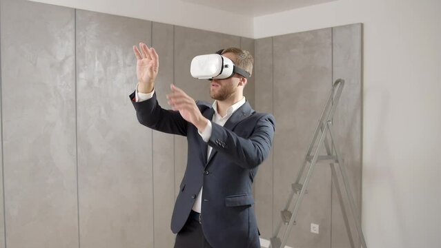 Man owner has put on vr technology and estimates the apartment already furnished. Man using virtual reality for seeing his new apartment already furnished