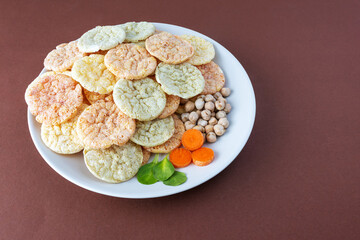 Chickpea chips snack with vegetables on a brown background