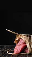 Fresh meat in a paper bag on a dark background