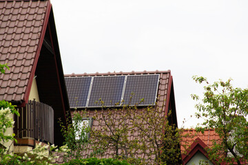 Fototapeta na wymiar Installing a Solar Cell on a Roof. Solar panels on roof. Historic farm house with modern solar panels on roof and wall. High quality photo