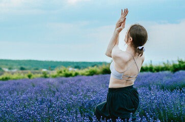Side view of woman doing yoga in rural lavender field 