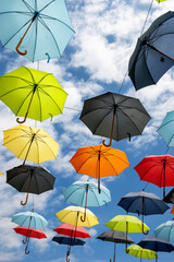 Fototapeta na wymiar Colorful umbrellas hanging above a street