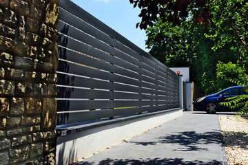 medium gray metal fence and gate. horizontal panels and gaps. powder coat finish. diminishing...