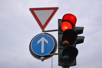 Traffic control signs and traffic light with red prohibitive color on the road pole on sky...