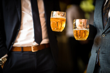 People drinking beer together at a company party, well dressed.