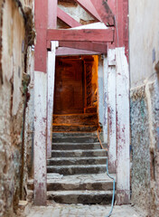 Old Ottoman and arabic sculpted door of a house in the Casbah, Algiers (Alger), Algeria. Typical wooden architectural structure to prevent the houses from falling apart. White walls.