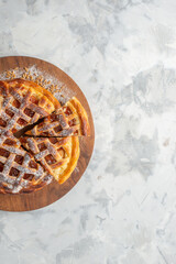 Half shot of delicious jam pie on brown board on ice background with free space