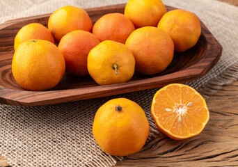 Cravo or rose lemons in a bowl over wooden table