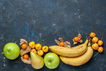 top view yellow bananas pair of berries with fresh green apples pears sweet cherries on the dark-blue desk fruit berry health vitamine - obrazy, fototapety, plakaty