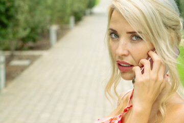 PRETTY GIRL SMILING WHILE IS TAKING A SELFIE AND CALLING BY PHONE IN THE STREET