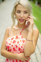 PRETTY GIRL SMILING WHILE IS TAKING A SELFIE AND CALLING BY PHONE IN THE STREET