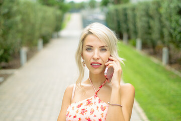 PRETTY GIRL SMILING WHILE IS TAKING A SELFIE AND CALLING BY PHONE IN THE STREET