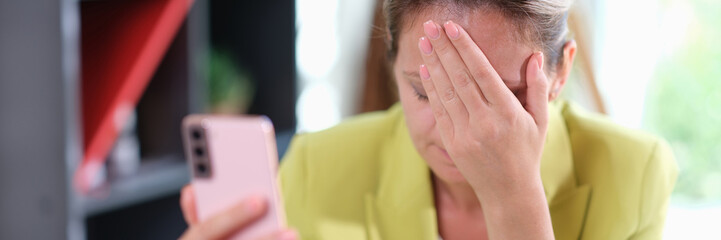 Young business woman on phone embarrassed by receiving sms with bad news