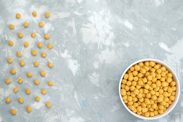 Fototapeta na wymiar top view yellow cereals lined on the light background breakfast food meal cereal